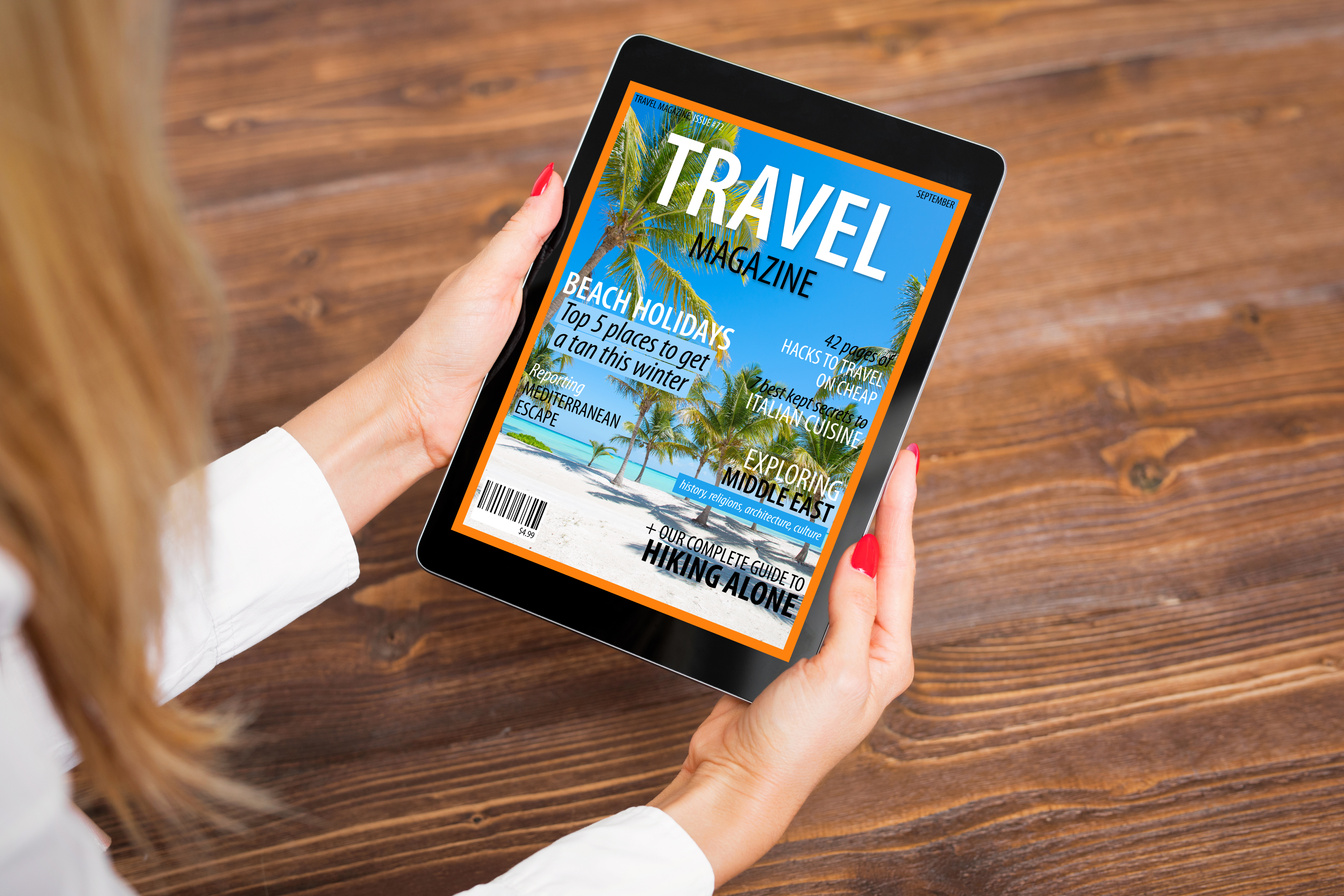 Woman reading travel magazine on tablet